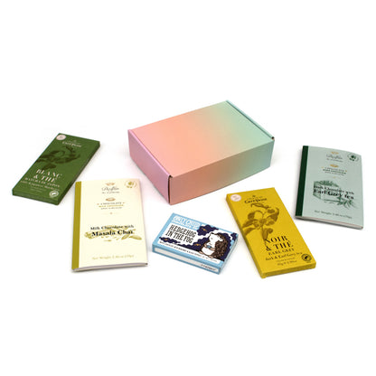 A curated gift box set featuring a pastel gradient box and five assorted chocolate bars from Chocosphere arranged on a white background.