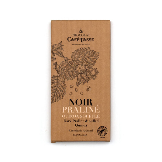 A chocolate bar in its kraft paper packaging, featuring the brand 'Chocolat Café-tasse' and the flavor 'Noir Praliné' with illustrations of leaves on a white background.