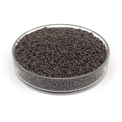 A glass dish full of small dark chocolate chips photographed on a white background.