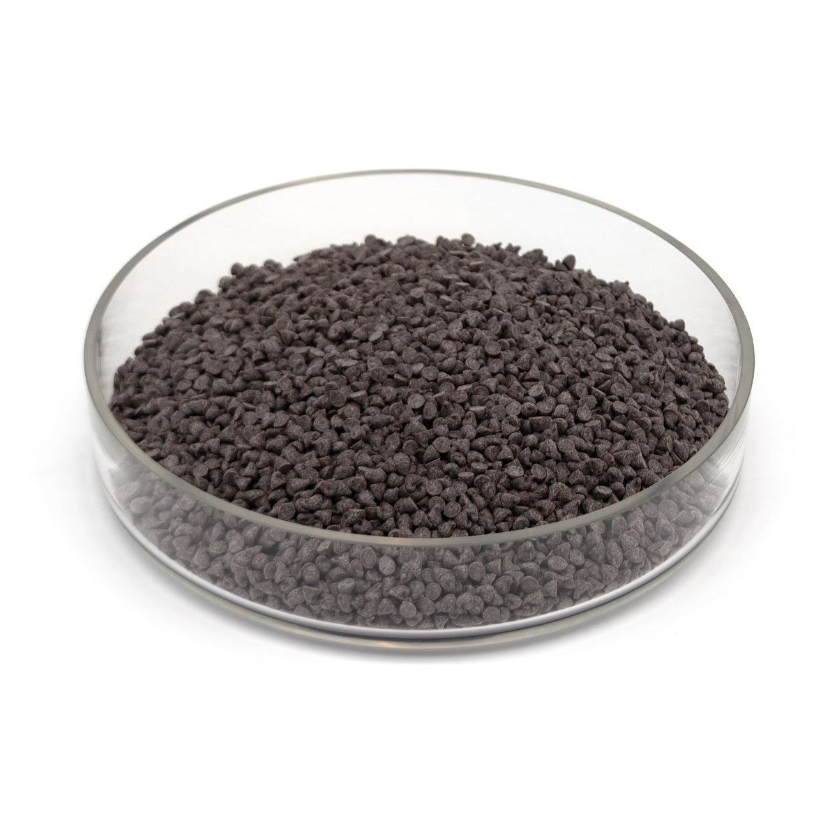 A glass dish half full of small dark chocolate chips photographed on a white background.