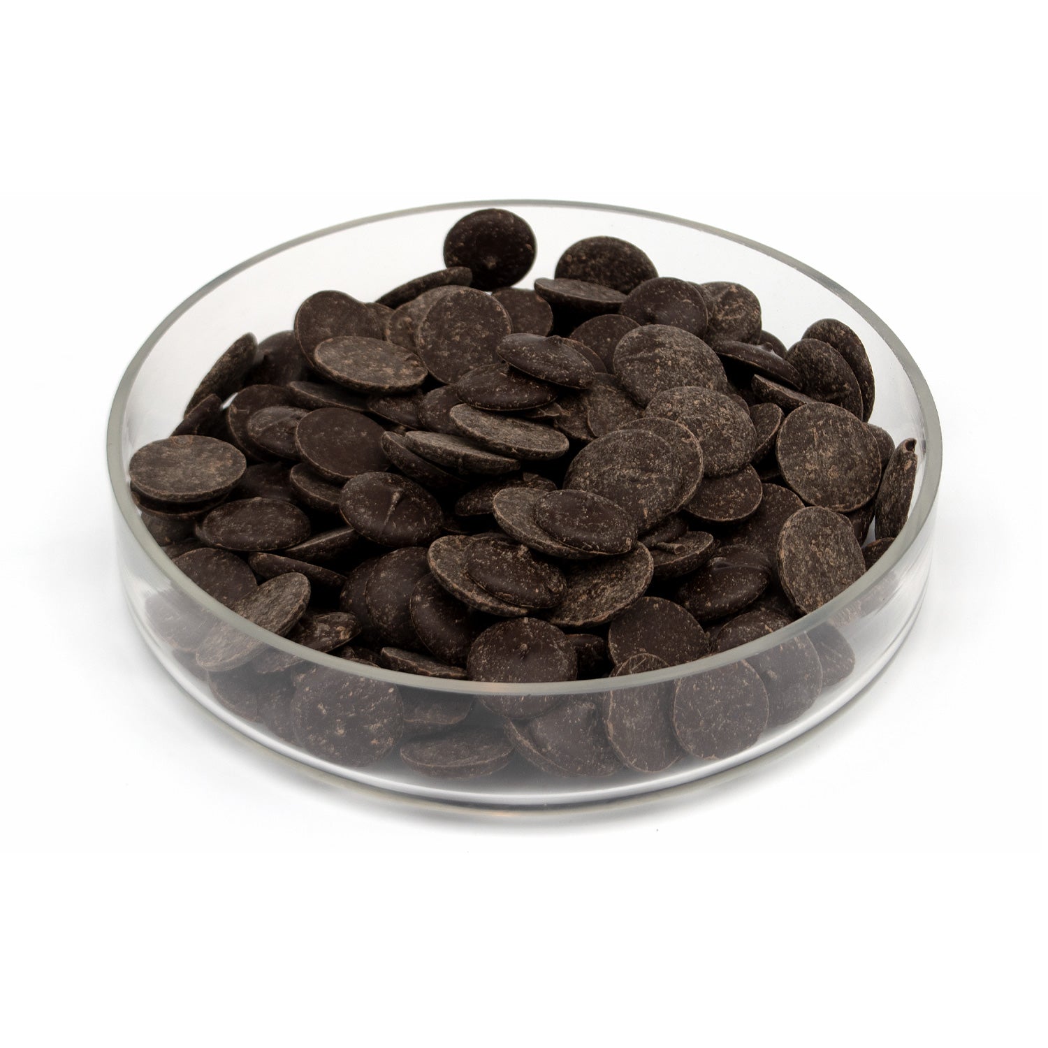 Dark chocolate wafers piled in a clear glass bowl on a white background.