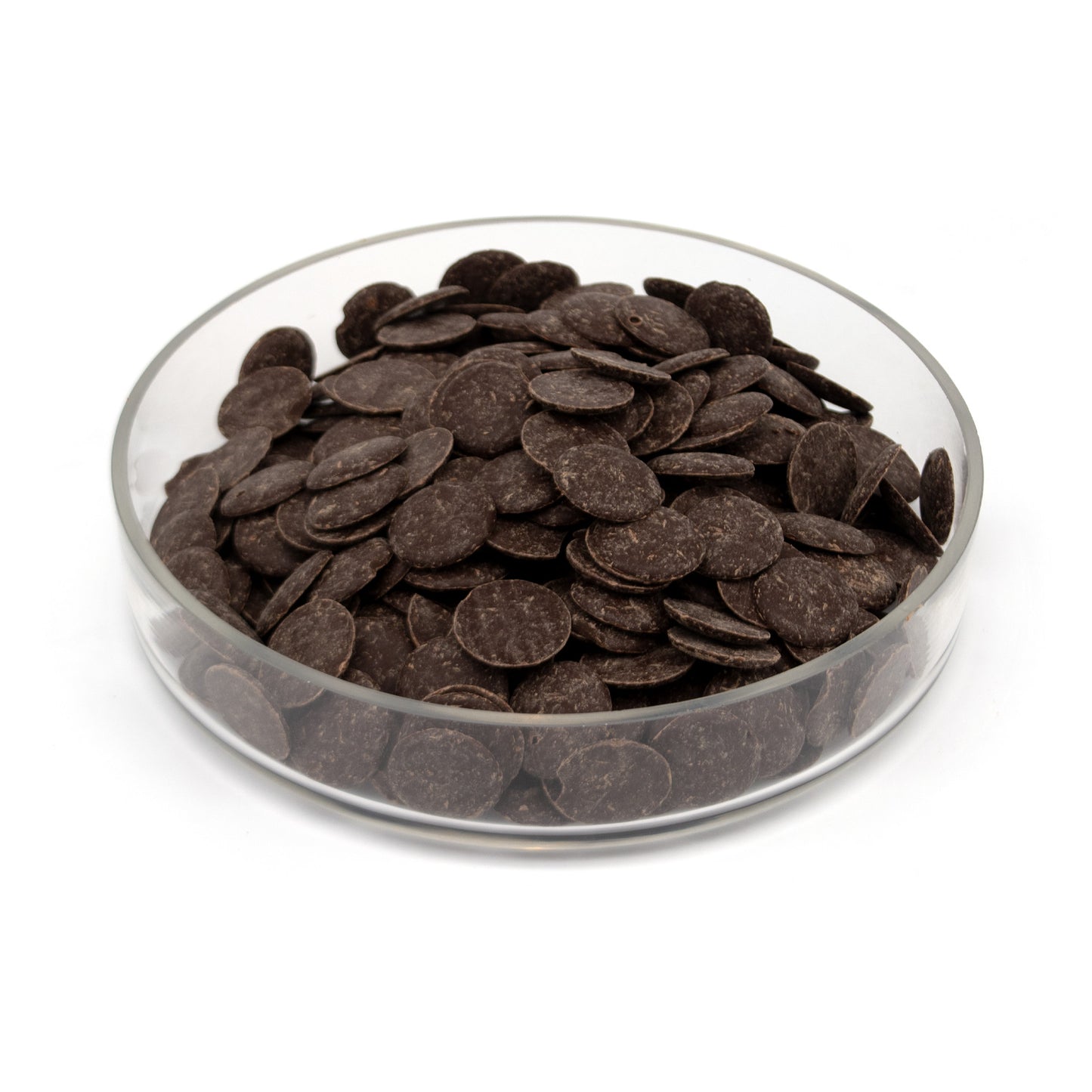 Dark chocolate wafers piled in a clear glass bowl on a white background.