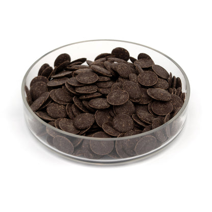 Glass container filled with dark chocolate wafers on a white background