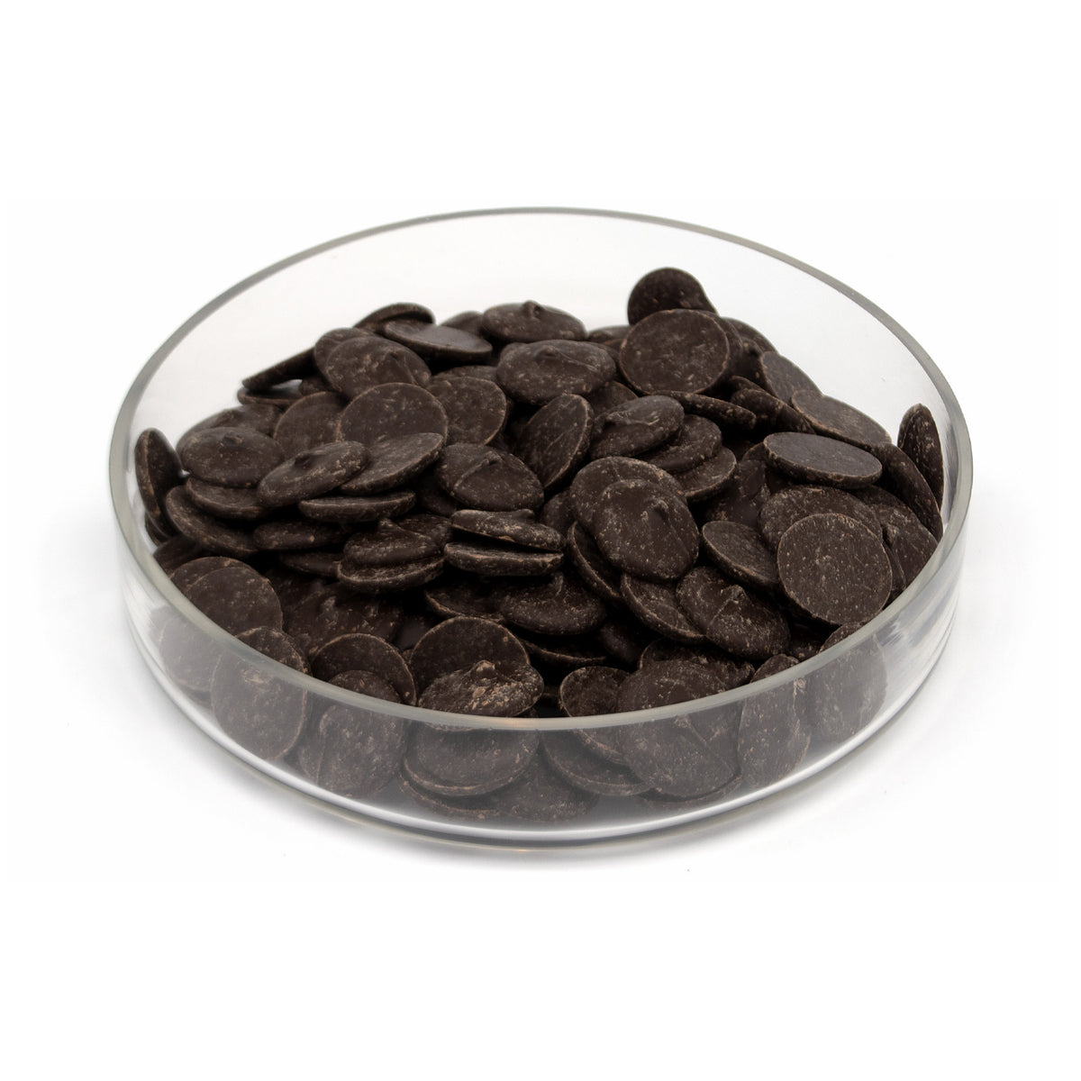 Dark chocolate wafers piled in a clear glass bowl on a white background.