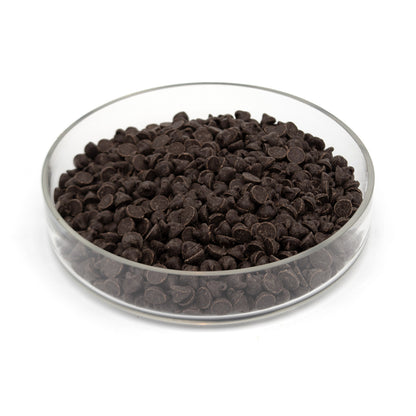 Dark chocolate chips in a clear glass bowl on a white background.