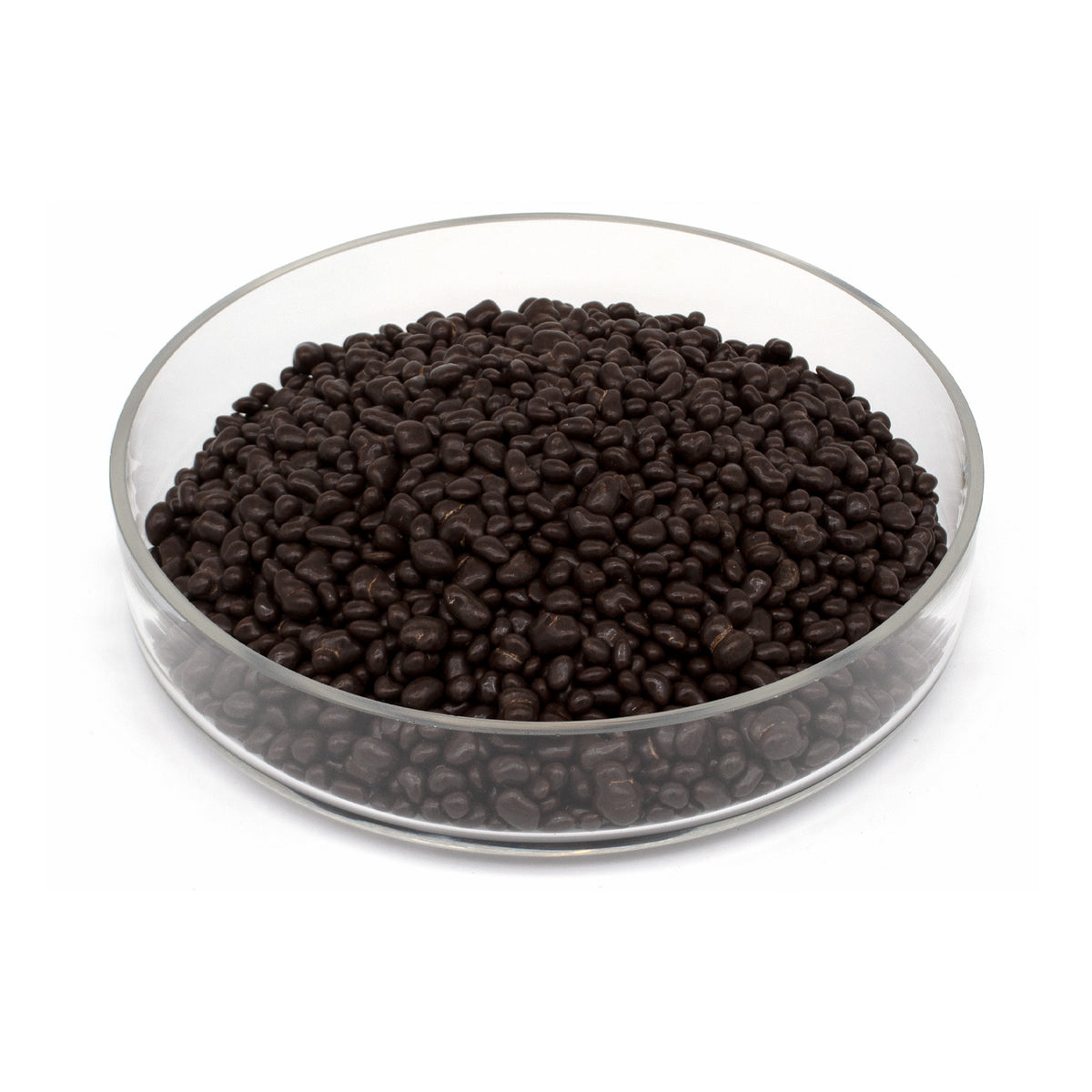 A pile of dark brown chocolate covered cacao nibs in a clear glass bowl, photographed on a plain white background.