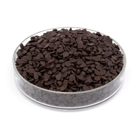 Clear glass bowl filled with dark chocolate chips on a white background