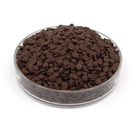 A clear glass bowl filled with dark brown chocolate discs, photographed on a clean white background.